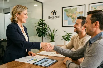Agent immobilier signant un contrat de vente avec un couple dans une agence moderne
